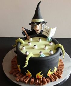 a cake decorated with a witch's hat and spell book on top of it