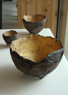 two metal bowls sitting on top of a table