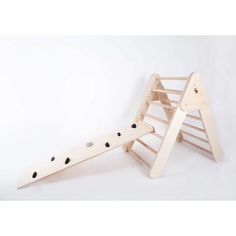 a wooden toy slide with black dots on it