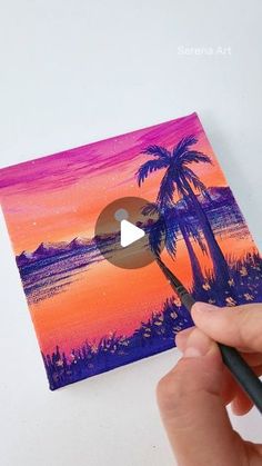 someone is painting a palm tree with purple and orange colors in the background, while holding a black brush