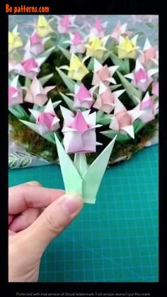 someone is making origami flowers out of paper