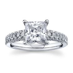 a princess cut diamond engagement ring with pave set diamonds on the band and shoulders