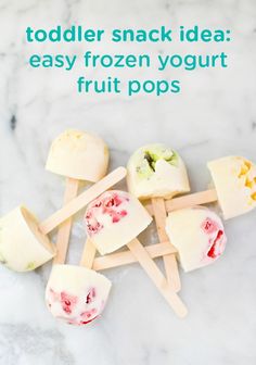 popsicles with strawberries and kiwis on them sitting on a marble surface