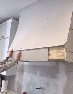 a man working on a stove top in a room under construction with unfinished walls and cabinets