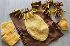 a baby's yellow and brown outfit is laying on the floor next to other items