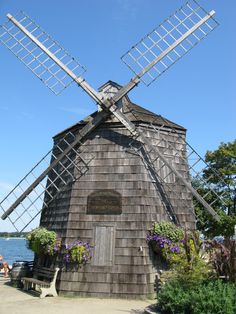 an old wooden windmill sitting next to the ocean