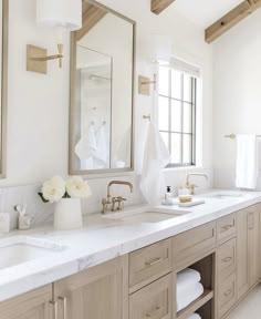 a large bathroom with two sinks and mirrors