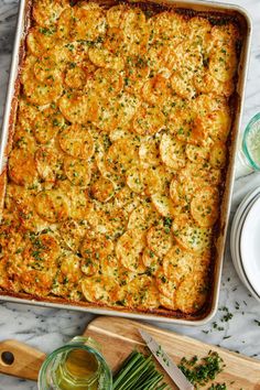 a casserole dish on a marble counter top with green onions and parsley