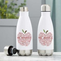 two personalized stainless steel water bottles on a marble countertop with an apple in the middle