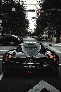 a black sports car is parked on the street