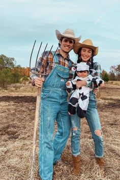 a man, woman and child are posing for a photo in the field with their farm equipment