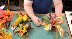 a person is cutting up flowers on a table with scissors and other items around it