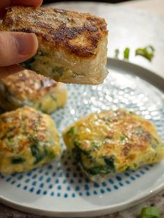 a person is holding up some food on a plate with broccoli and cheese