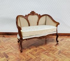 an old wooden bench sitting on top of a hard wood floor next to a wall