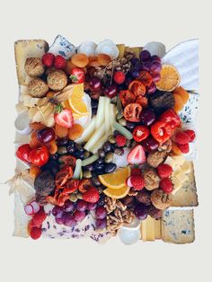 an assortment of cheeses, fruits and nuts arranged on top of each other