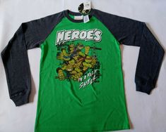 a green and black t - shirt with the image of teenage mutant ninjas on it