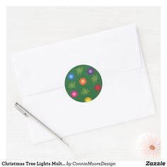 a white envelope with a green christmas ornament on it and a pen next to it