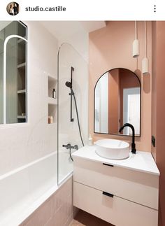 a white sink sitting under a mirror in a bathroom next to a bathtub and shower