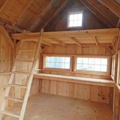 a loft with wooden walls and ladder to the second floor