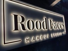 a lighted sign for a makeup studio that says,'rootfaces make up studio '