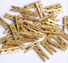 gold colored wooden clothes pegs on white background