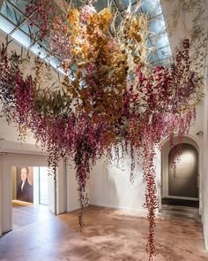 an art installation with flowers hanging from the ceiling