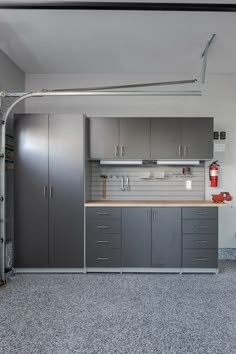 a kitchen with gray cabinets and grey flooring in the middle of it is shown