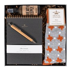 a notepad, pen and notebook in a gift box with an orange maple leaf design