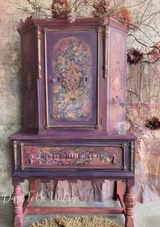 an old dresser painted in pink and purple with flowers on it, next to a rug