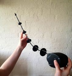 a person is holding up a string with black balls on it and two strings attached to them