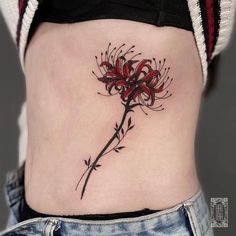 a woman's stomach with a flower tattoo on it