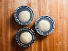 three bowls with dough in them sitting on a wooden table