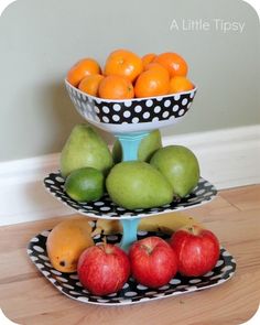 three tiered trays filled with fruit on top of a wooden floor