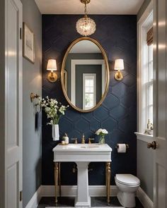 a bathroom with a sink, toilet and mirror on the wall next to two windows