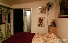 a bedroom with a bed, window and pictures on the wall next to the door