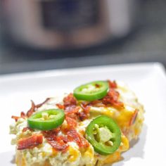 an omelet with green peppers and cheese on it sitting on a white plate