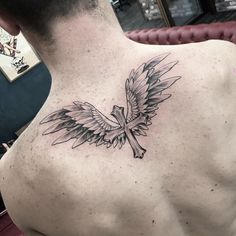 a man with a cross and wings tattoo on his back