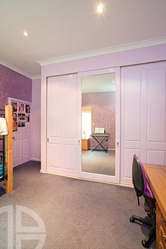 a bedroom with purple walls and carpeted flooring has a bunk bed, desk, and chair