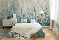 a bed sitting in a bedroom next to a wall covered in blue and white flowers