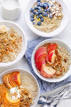 three bowls of oatmeal with apples, blueberries, and almonds