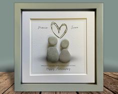 two pebbles sitting on top of each other in a frame