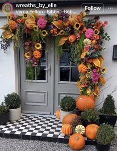 the front door is decorated with flowers and pumpkins