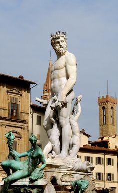 the statue is in front of some buildings