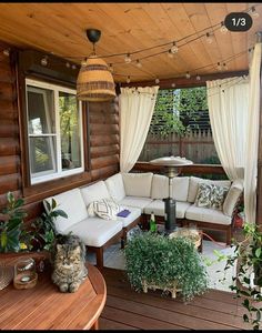 an outdoor living area with couches, tables and potted plants on the deck