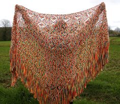 an orange shawl draped over a green field