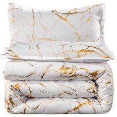 a white and gold marbled sheet set with two pillows on top of each one