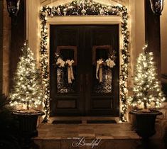 christmas lights decorate the front door of a house with wreaths and garland on it