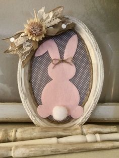 a pink bunny decoration in a white frame