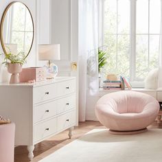 a bedroom with white furniture and pink accessories on the dressers, windows, and rug