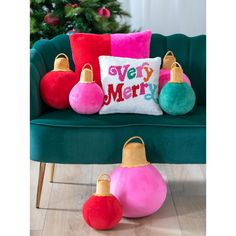 a green couch with christmas ornaments on it and a merry pillow sitting next to it